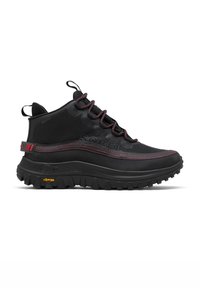Bottes hautes noires imperméables avec des accents rouges, présentant une surface texturée, une semelle en caoutchouc robuste et la marque Vibram sur la semelle extérieure.
