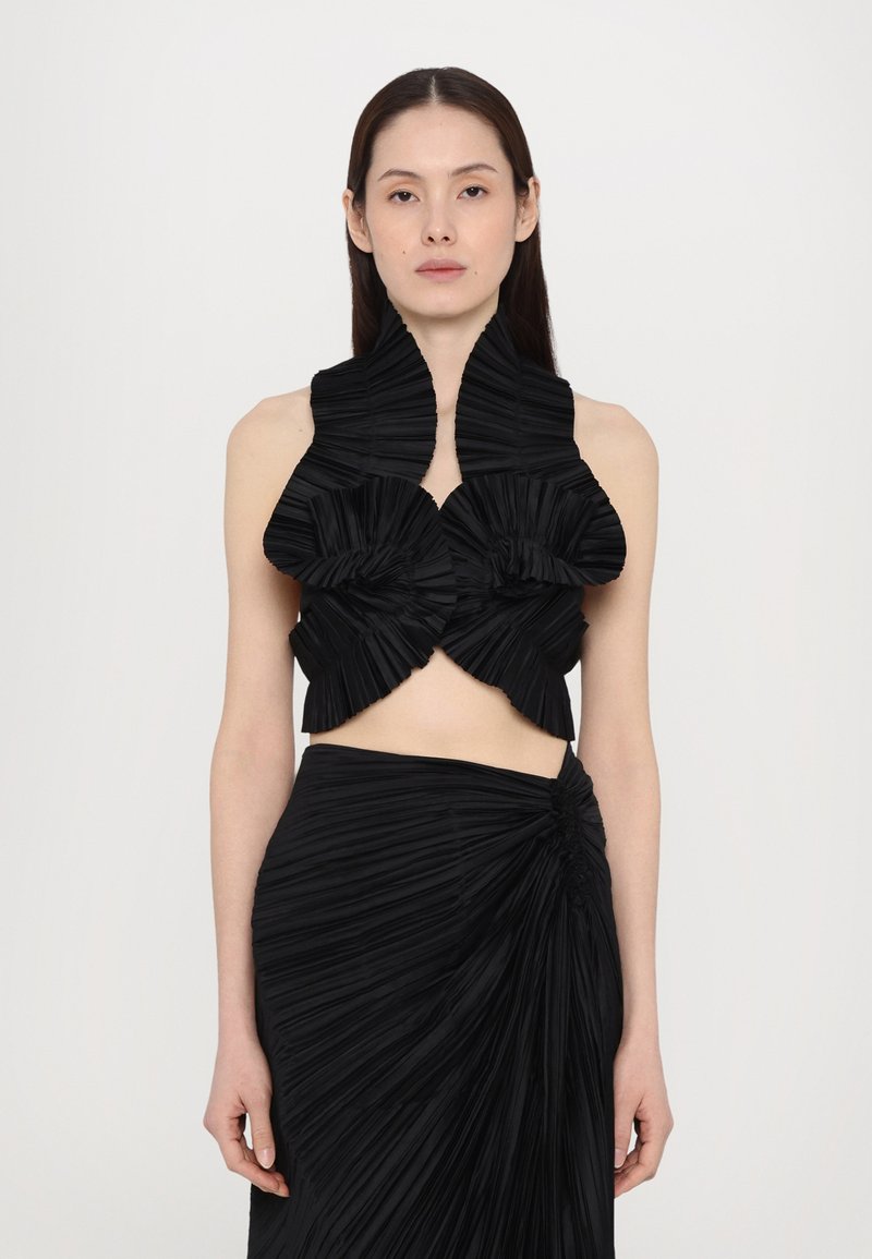Black two-piece outfit featuring a pleated crop top with oversized ruffled details and a fitted pleated skirt with a twisted accent at the waist.