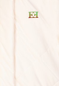 Giacca trapuntata crema con un motivo a rombi, caratterizzata da un piccolo logo multicolore. Tessuto liscio e leggero.