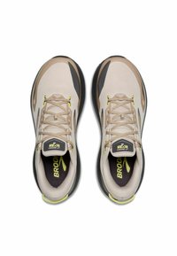 Baskets en maille beige avec des accents noirs et gris, présentant des touches de jaune clair, un bout rond et des lacets plats. Logo "Brooks" sur la languette.