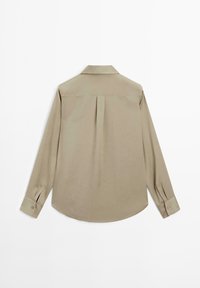 Lichtolijfkleurig groen shirt met lange mouwen, een plooien aan de achterkant, een puntige kraag en manchetten met knopen. Gladde stoftextuur en een afgeronde zoom.