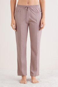 Světle mauve elastické kalhoty s páskem na stažení, dvěma bočními kapsami a uvolněným střihem. Měkká tkanina s hladkou strukturou.