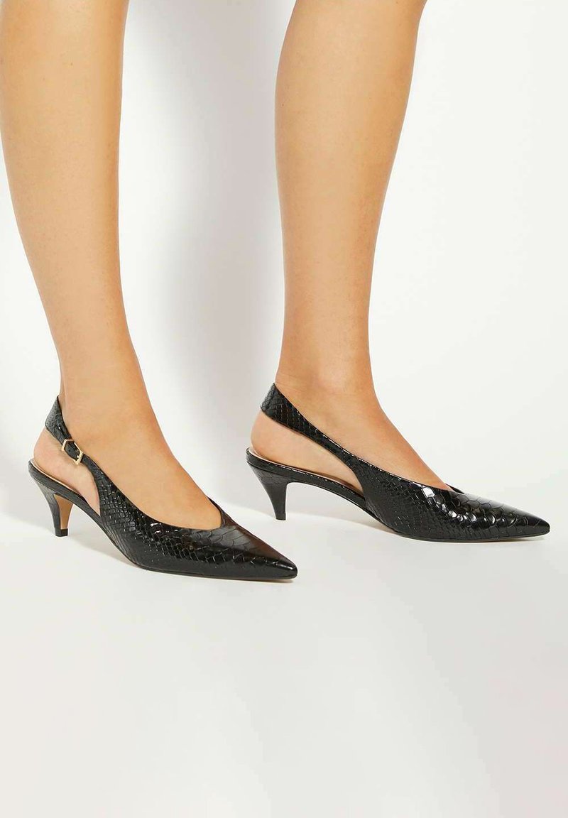 Black slingback heels with pointed toes, made of textured patent leather resembling snake skin. Features a small heel and ankle strap with buckle.