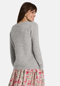 Grauer Strickpullover mit gerippter Textur, rundem Halsausschnitt und langen Ärmeln, mit einem kleinen dekorativen Knopf auf der Rückseite.