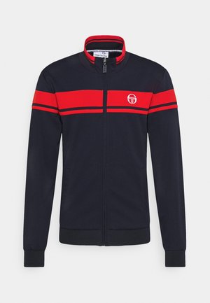 Veste noire zippée intégrale avec des rayures horizontales rouges sur la poitrine et les manches, col intérieur rouge et logo blanc sur le côté gauche de la poitrine.