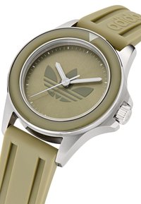 Zöld szilikon szíjas óra ezüst rozsdamentes acél tokban, kerek formájú, minimalista számlappal, fehér mutatókkal és középen Adidas logóval.