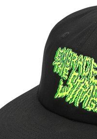Gorra negra con una forma estructurada que presenta texto bordado en neón verde elevado "ABRAZA LO EXTRAÑO" con un estilo de fuente distorsionado.