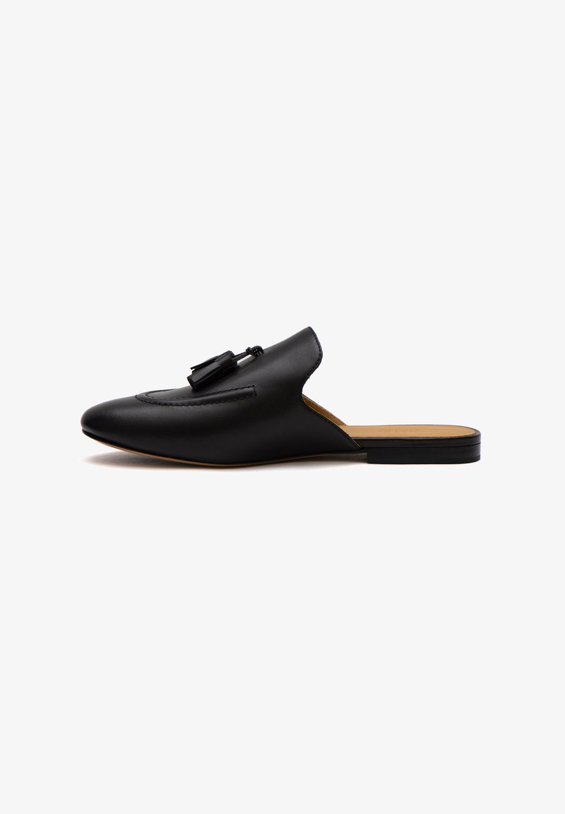 Schwarze Leder-Mules mit spitzem Zeh, Vordernahtdetails und Quastenakzenten am Rist. Flache Sohle mit einem leichten Absatz.