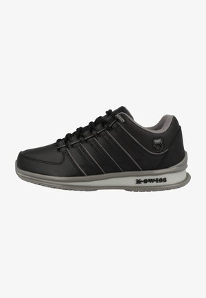 Černá sportovní bota se syntetickým svrškem, texturovanými panely, systémem šněrování a šedými akcenty. Obsahuje polstrovanou podrážku s logem značky.