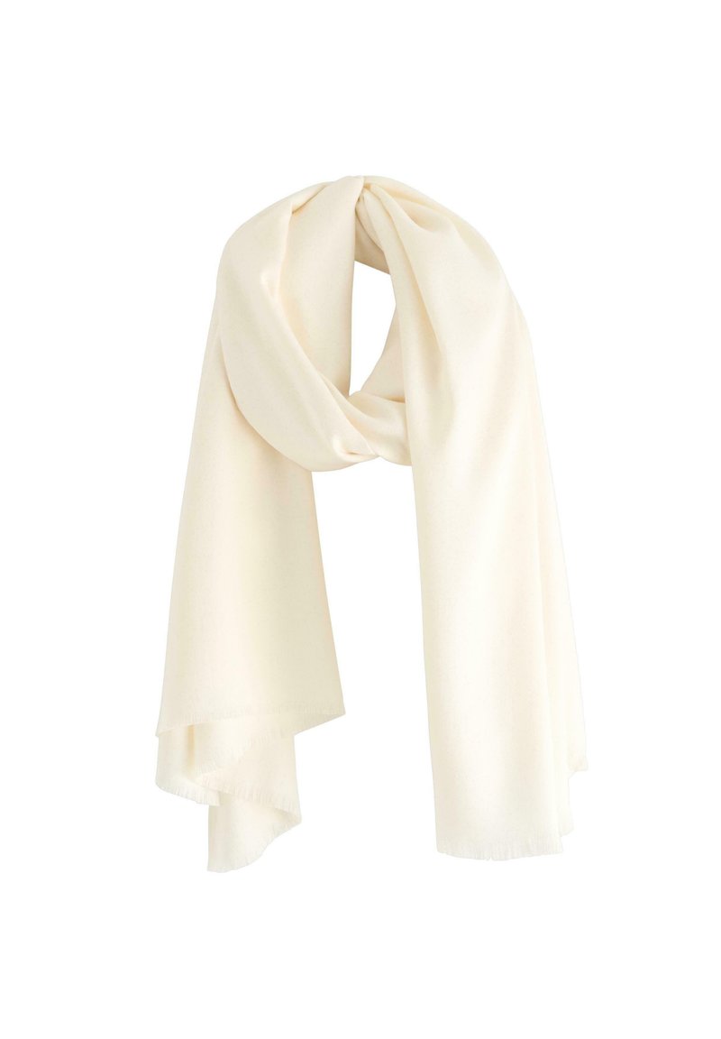 Světlý krémový šátek z měkké tkaniny s hladkým povrchem a třepenými okraji, zavěšený v zamotaném uspořádání.