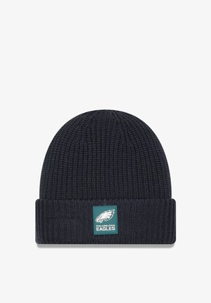 Dark navy knitted beanie with a folded cuff. Features a green and white Philadelphia Eagles logo patch on the front. Textured fabric.