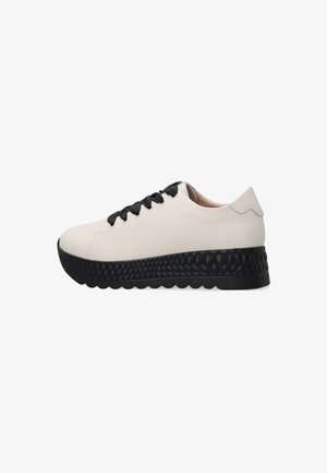 Weißes Leder-Sneaker mit einer strukturierten schwarzen Sohle, ausgestattet mit schwarzen Schnürsenkeln und einer glatten Rückseite. Die Seitenansicht hebt die kontrastierenden Elemente hervor.