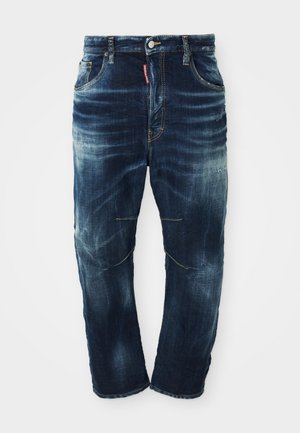 Dunkelblaue Jeans aus Denim mit ausgewaschenem Look, Fünf-Taschen-Design, Reißverschluss und kontrastierenden Nähten. Sie weisen eine leichte Abnutzung an den Knien auf.