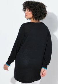 Zwarte gebreide trui met lange, ballonmouwen. Heeft een ronde halslijn en blauwe accenten bij de manchetten, ontworpen voor een ontspannen pasvorm.