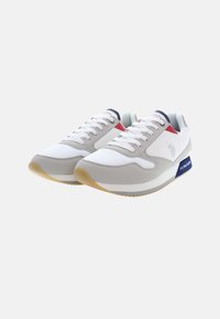 Scarpe sportive con una tomaia in rete bianca, dettagli in suede grigio, particolari rossi e blu navy, e una suola in gomma con battistrada testurizzato.