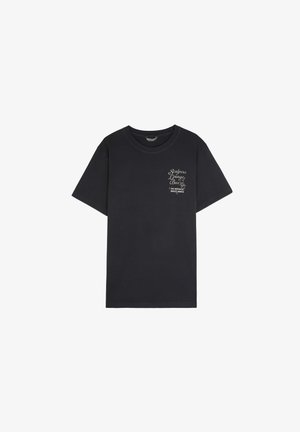 Camiseta de algodón negra con cuello redondo, mangas cortas y un logo impreso en el lado izquierdo del pecho. Ajuste estándar.