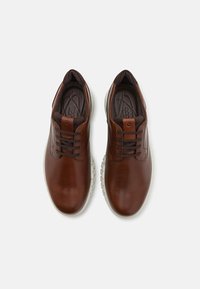 Brown leather lace-up shoes with a smooth surface, round toe, and rubber sole featuring textured accents along the sides.