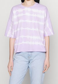 Laventelinvärinen kankainen t-paita, jossa on lyhyet hihat, pyöreä pääntie ja vaakasuorat valkoiset raidat. Löysä malli ja lyhennetty helma.