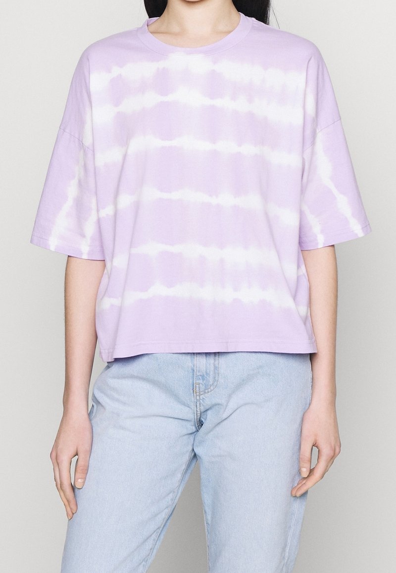 Laventelinvärinen kankainen t-paita, jossa on lyhyet hihat, pyöreä pääntie ja vaakasuorat valkoiset raidat. Löysä malli ja lyhennetty helma.