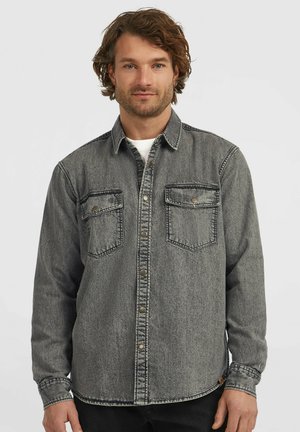 Denim overhemd in een vervaagde grijze kleur. Heeft een knoopsluiting, twee borstzakken en een klassieke kraag. Gestructureerde stof met zichtbare stiksels.