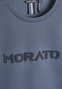 Sivi pamučni T-shirt s okruglim izrezom i regularnim krojem, s teksturiranim tamnosivim logotipom "MORATO" sprijeda.
