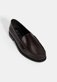 Bruine leren loafer met een gladde afwerking, gekenmerkt door een klassiek ontwerp met stikselaccenten en een iets verhoogde hak.
