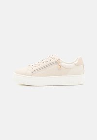 Sneaker rosa chiaro con pannello testurizzato, suola bianca piatta, design con lacci e cerniera laterale con un charm decorativo.