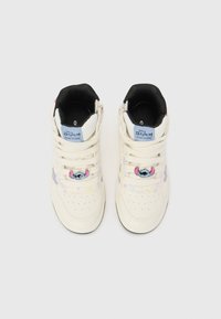 Cream-colored high-top sneakers with colorful Stitch designs, black lining, blue label, and decorative hardware on the front.