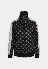 Black zip-up jacket with white patterned accents, high collar, and pink logo detail. Made from textured fabric with ribbed cuffs.