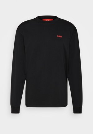 Black long-sleeve shirt with a red "032" embroidery. The model wears red pants and a white scarf with red checkered patterns.