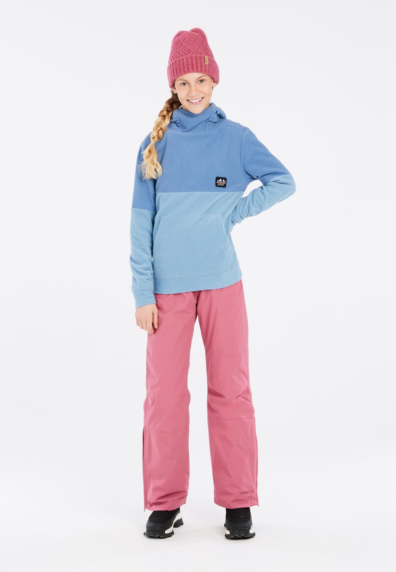 Pull en polaire bleu clair avec un bonnet en tricot rose, associé à un pantalon imperméable rose. Il comporte une poche kangourou et une patch logo.