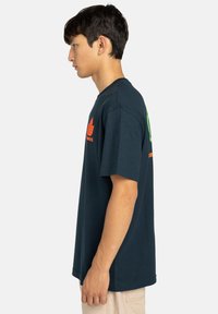 Navy blue cotton t-shirt with short sleeves. Features orange leaf logo and text on the chest and green text on the back. Straight cut design.