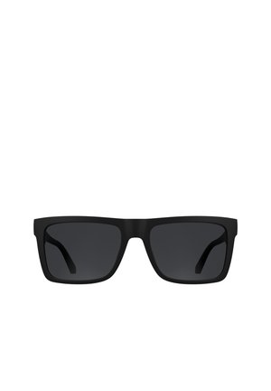 Schwarze rechteckige Sonnenbrille mit dicken Rahmen und dunkel getönten Gläsern vor weißem Hintergrund.