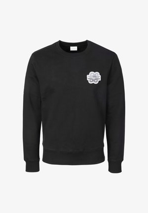 Sweat-shirt noir à col ras du cou avec manches longues et poignets côtelés, présentant un petit patch abstrait blanc et gris sur la poitrine gauche.