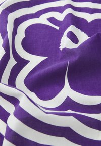 Lilla stoff med hvite abstrakte mønstre. Materialet ser mykt ut med en teksturert finish. Designet inkluderer runde former og buede linjer.