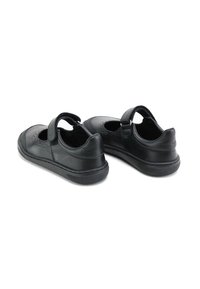 Zapatos Mary Jane de cuero negro con punta redonda, detalles perforados en los lados y una correa de Velcro para un ajuste seguro. Suela de goma.