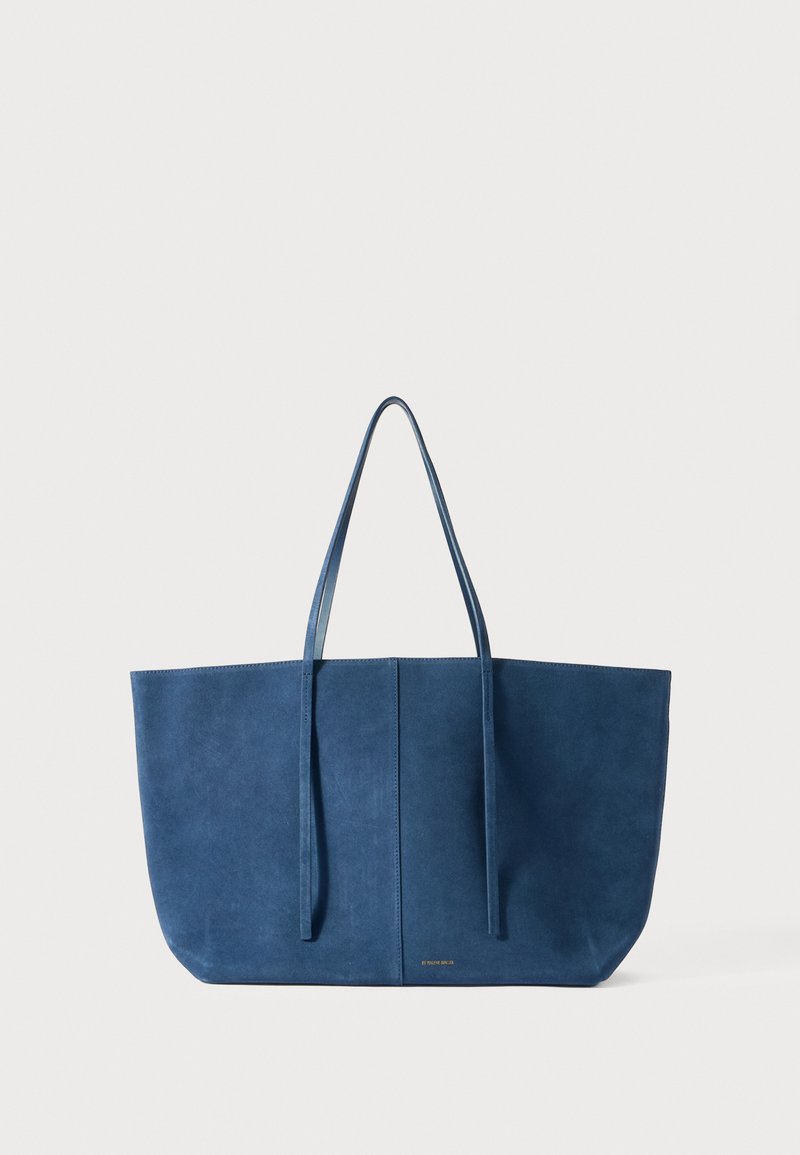 Μπλε σουέτ τσάντα ώμου με δύο μακριές λαβές, ορθογώνιο σχήμα, λεία υφή, μινιμαλιστικός σχεδιασμός με μια διακριτική λογότυπη στην εμπρόσθια πλευρά.