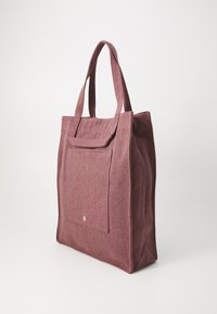 Bordeaux tote bag laget av teksturert stoff, med to korte håndtak, en frontlomme og en subtil logo detalj på lommen.