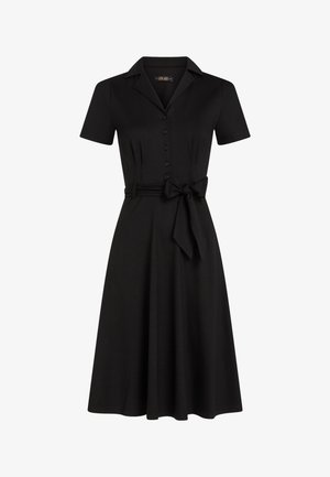Czarna sukienka z krótkim rękawem, z przodu zapinana na guziki, z kołnierzykiem i paskiem w talii do regulacji. Gładka tkanina, długość do kolan, klasyczny krój.