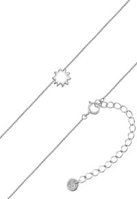 Sølvarmbånd med en solstrålevedhæng. Glat metaloverflade, fine kædeled og en rund lukning med logoaccent.