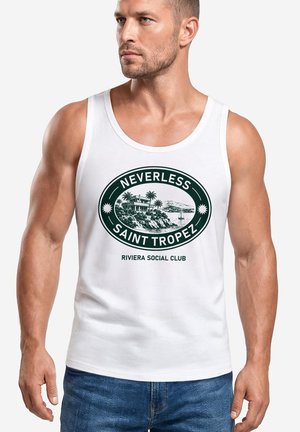 Muskelbepackter Mann trägt ein weißes Tanktop mit einer Küstenszene von Saint Tropez und dem Text "Nevertheless Saint Tropez Riviera Social Club."