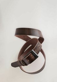 Ceinture en cuir brun avec une texture lisse, dotée d'une boucle en métal noir et de plusieurs trous d'ajustement, enroulée sur un fond clair.