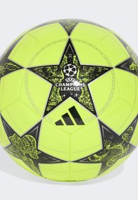 Fotbalový míč Adidas UEFA Champions League v zářivě neonově žluté barvě s černým hvězdicovým vzorem, zdobený ilustracemi hráčů a logy.