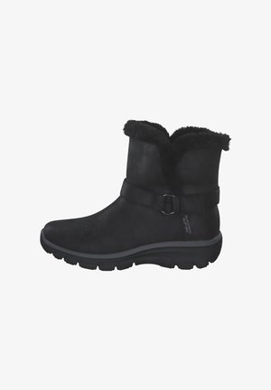 Zwarte enkelboots van suede met een nep-bont manchette, een riem met een gesp, en een gevoerde zool voor comfort.
