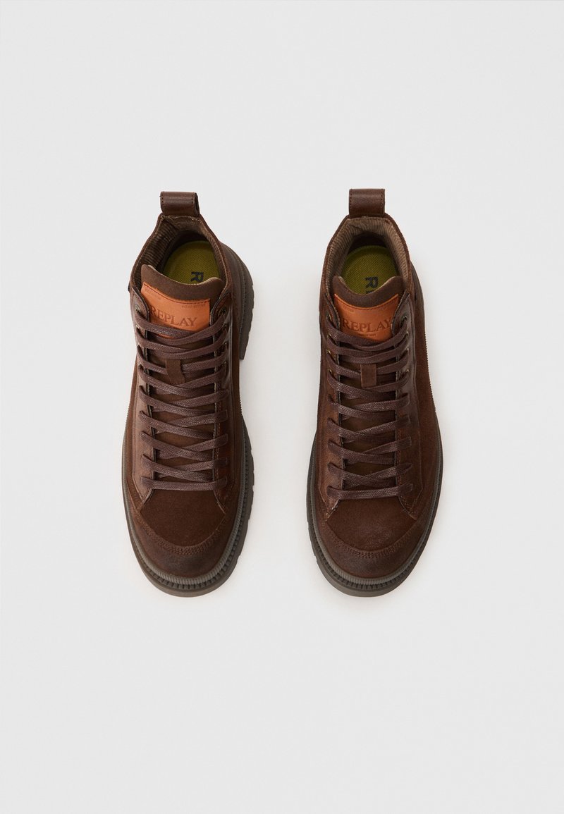 Braune High-Top-Sneaker aus einer Mischung von Leder und Wildleder, runder Zehenform, robuste Schnürsenkel und eine strukturierte Gummisohle.