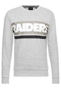 Sweatshirt gris à manches longues, présentant une large bande horizontale beige et noire, affichant en lettres blanches "RAIDERS".