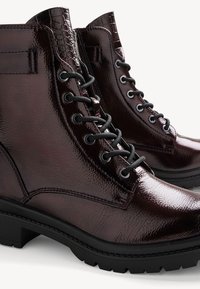Dunkelmaulbeerfarbene Leder-Stiefeletten mit glänzender Oberfläche, Schnürung an der Vorderseite und strukturierten Akzenten. Verfügt über eine robuste schwarze Sohle für besseren Halt.