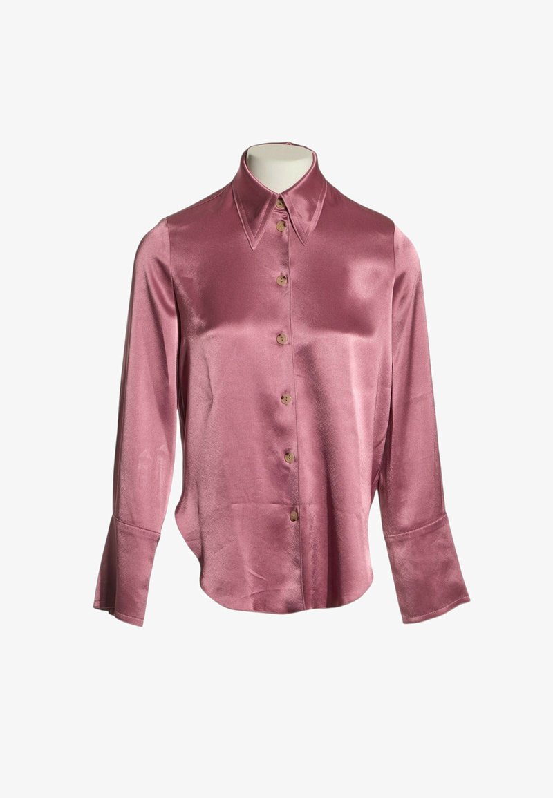 Blouse à manches longues en satin rose brillant avec boutons, larges poignets et col pointu sur un buste de mannequin blanc.