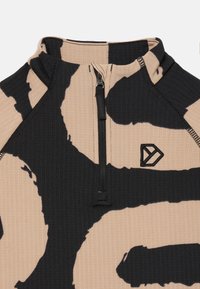 Ribbed zip-up top beežis musta abstraktse mustriga. Omab kõrget kraed ja väikest logo paremas alumises nurgas.