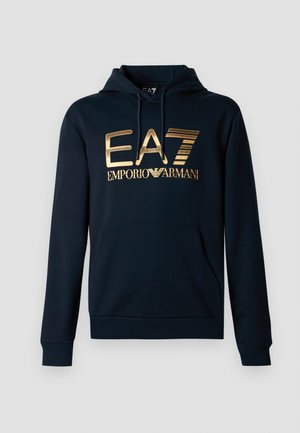 Tumesinine kapuutsiga pusa suure kuldse EA7 logoga; sisaldab känguru taskut, reguleeritavat kapuutsi ja soonikkoes käeotsi, et saavutada mugav ja slim-fit disain.